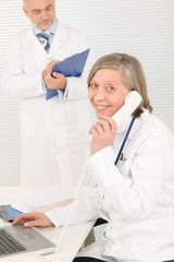 Medical team senior female phone male colleague