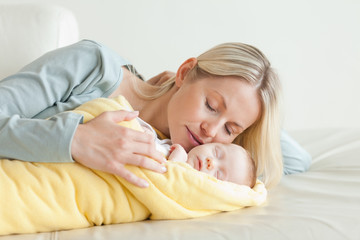 Obraz na płótnie Canvas Mother relaxing next to her sleeping baby