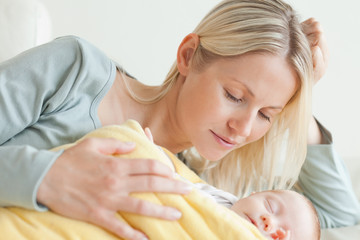 Obraz na płótnie Canvas Mother relaxing next to her baby