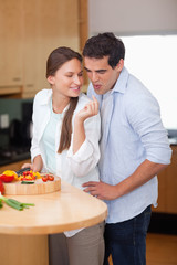 Portrait of a man blowing on his wife's finger