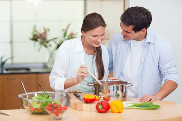 Obraz na płótnie Canvas Couple preparing a sauce