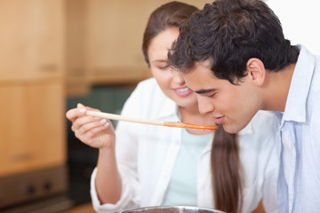 Close up of a man trying his wife's sauce
