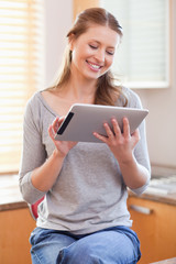 Smiling woman with tablet in the kitchen