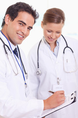Fototapeta premium Assistant doctors with patient record