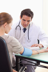 Obraz premium Doctor taking his patients blood pressure
