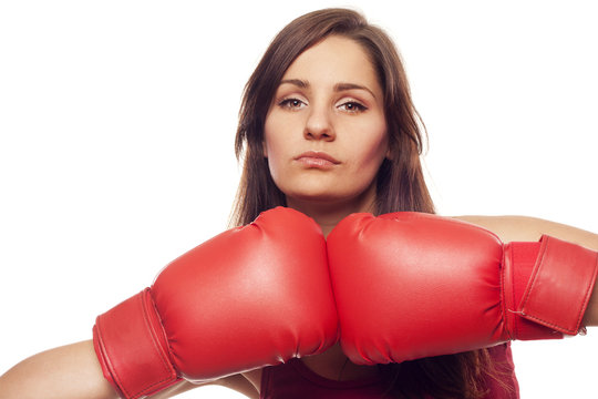 Pretty confident young woman with boxing gloves