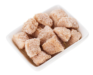 Brown lump cane sugar in a rectangular sugar-basin, isolated on