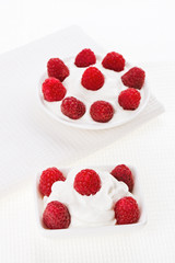 Still life with raspberry sour cream dessert on white linen tabl