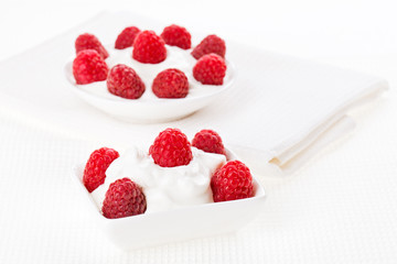 Still life with raspberry sour cream dessert on white linen tabl