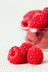 Still life with red raspberry and glass bowl on gray linen table