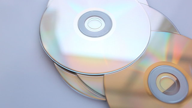 Compact disks fall on a table.