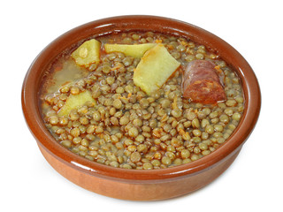 Cazuela de lentejas sobre fondo blanco.