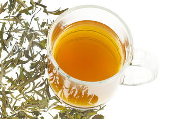 tea in glass cup and dried leaves