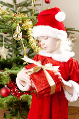 little girl as Santa Claus with Christmas present