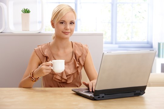 Young pretty woman with coffee and laptop