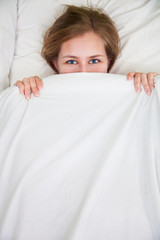 Portrait of young beautiful woman in bed