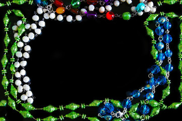 assorted bead necklaces forming a border on black