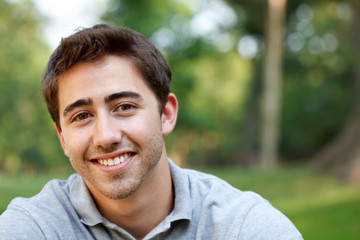 Young man portrait at the park with copy space