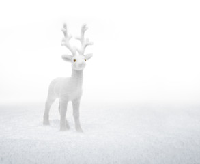 small white deer standing in the snow