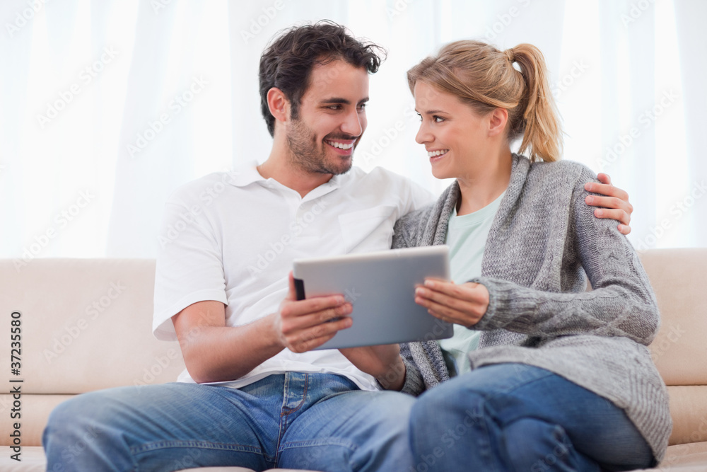 Poster young couple using a tablet computer