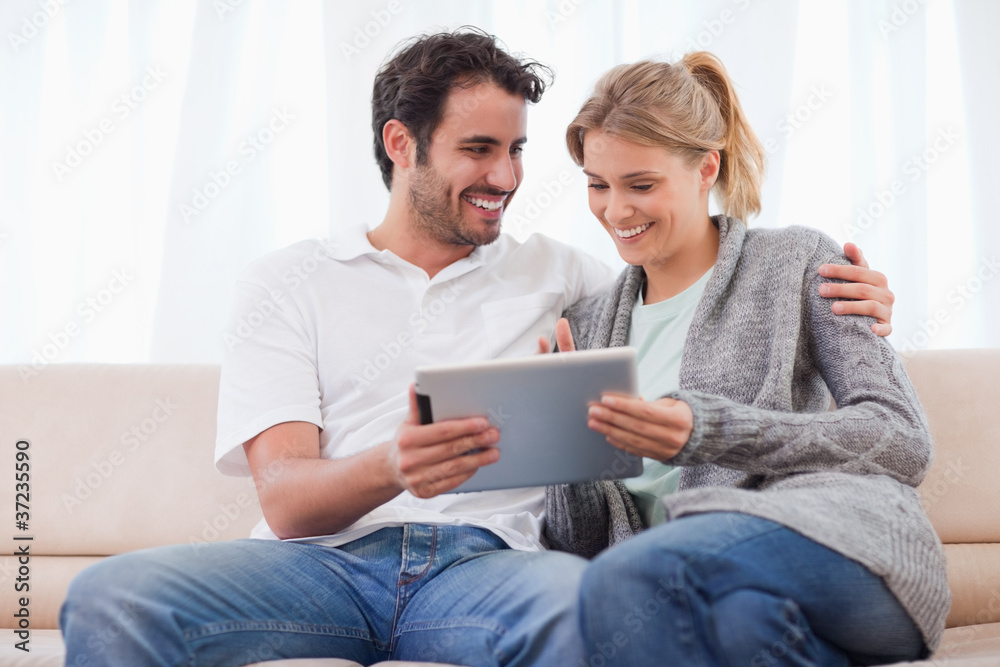 Poster happy couple using a tablet computer