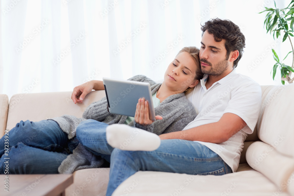 Poster lovely couple using a tablet computer