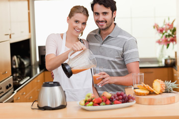 Young couple making fruits juice