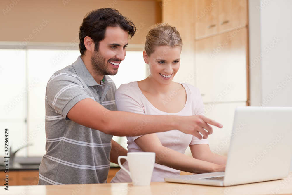 Poster Couple using a notebook while having coffee