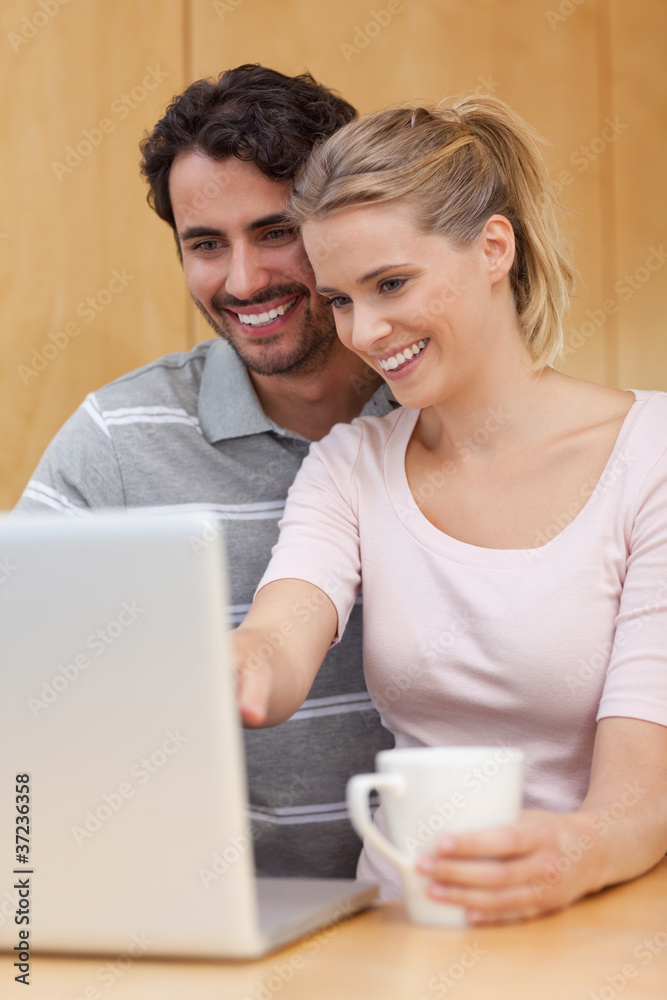 Poster Portrait of a couple using a notebook while having tea