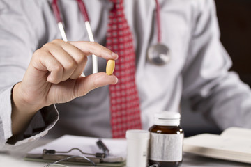 Vitamin, a doctor showing a pill of Vitamin in his hand.