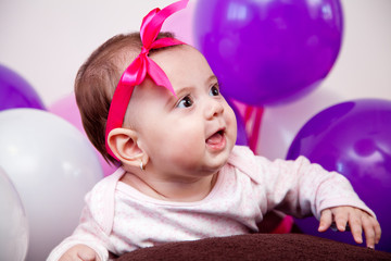 baby girl playing with balloons