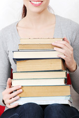 Female student holding a pile of books