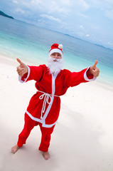 Young woman on the beach in santa's costume