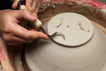 hands of a potter, creating an earthen jar on the circle