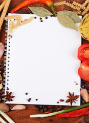 notebook for recipes and spices on wooden table