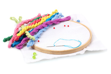 The embroidery hoop with canvas and bright sewing threads for