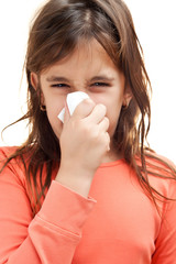Sick girl sneezing on a tissue isolated on white