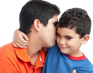 Latin father kissing his beautiful son isolated on white