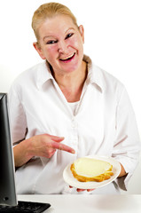 eine Büromitarbeiterin zeigt mit den Zeigefinger auf ein Brot