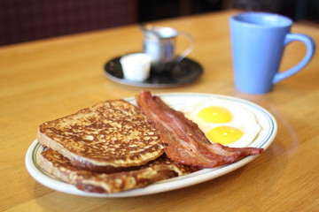 Delicious French toast with bacon and eggs for breakfast.