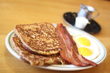Delicious French toast with bacon and eggs for breakfast.