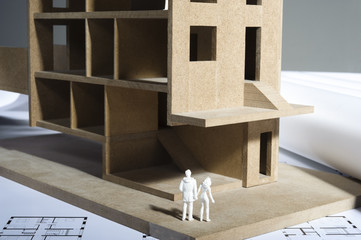 Modellhaus auf Bauplänen mit modellfiguren