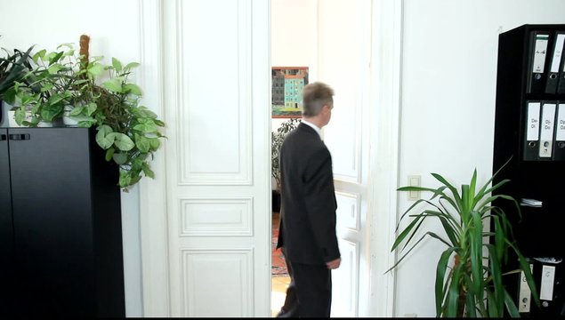 Ein Mann geht einem B&uuml;rozimmer durch die T&uuml;re
