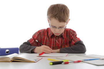 enfant garçon avec lunettes faisant ses devoirs