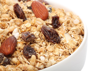 Close up of granola cereal on a bowl, over white background