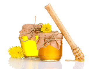 two jars of honey and wooden drizzler isolated on white