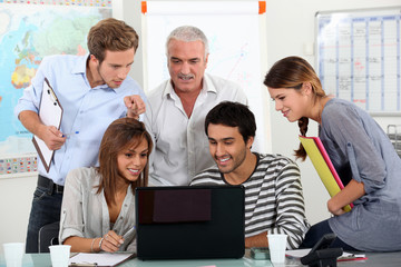 Students showing video to teacher on laptop computer