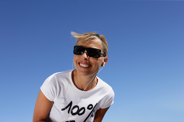 Naklejka premium Woman in sunglasses listening to music