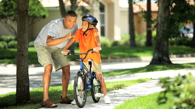Young Ethnic Father Encouraging Son on Bicycle