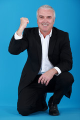 Portrait of a man rejoicing while kneeling on one knee